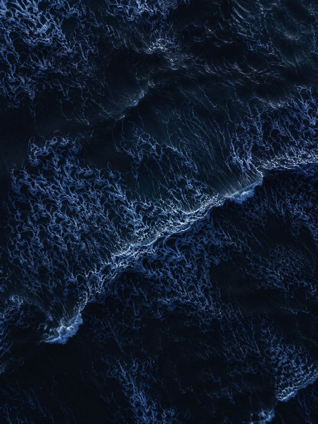 Aerial view of dark ocean waves at night